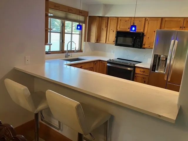 a kitchen with stainless steel appliances a microwave a sink and a refrigerator