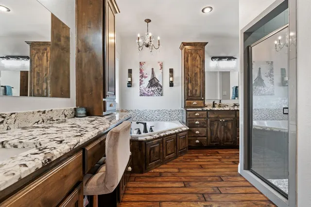 a spacious bathroom with a granite countertop sink a mirror and a shower