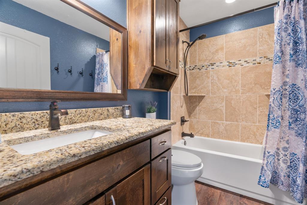 12190 Marion Road Sanger, TX 76266 - Photo 32 of 39 a bathroom with a granite countertop sink toilet and shower