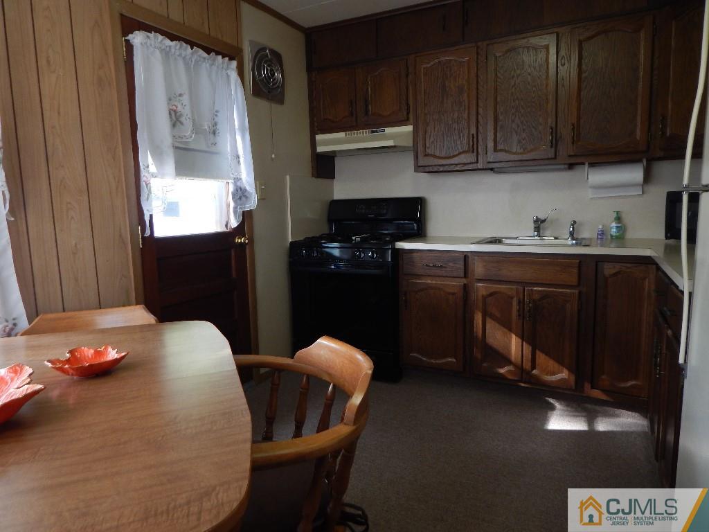 11 Dobson Road Edison, NJ 08817 - Photo 4 of 16 a kitchen with stainless steel appliances granite countertop a stove a refrigerator a sink a dining table and chairs with wooden floor