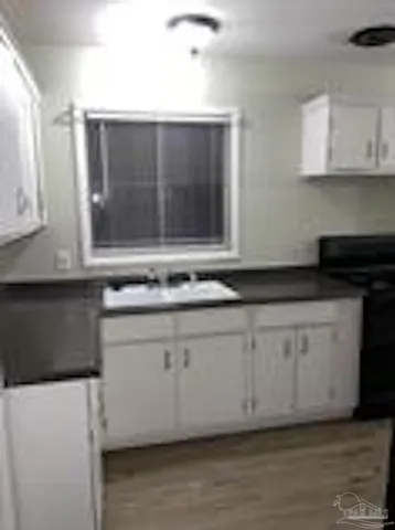 a kitchen with granite countertop white cabinets white stainless steel appliances and a sink