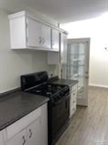 a kitchen with stainless steel appliances granite countertop white cabinets and a stove