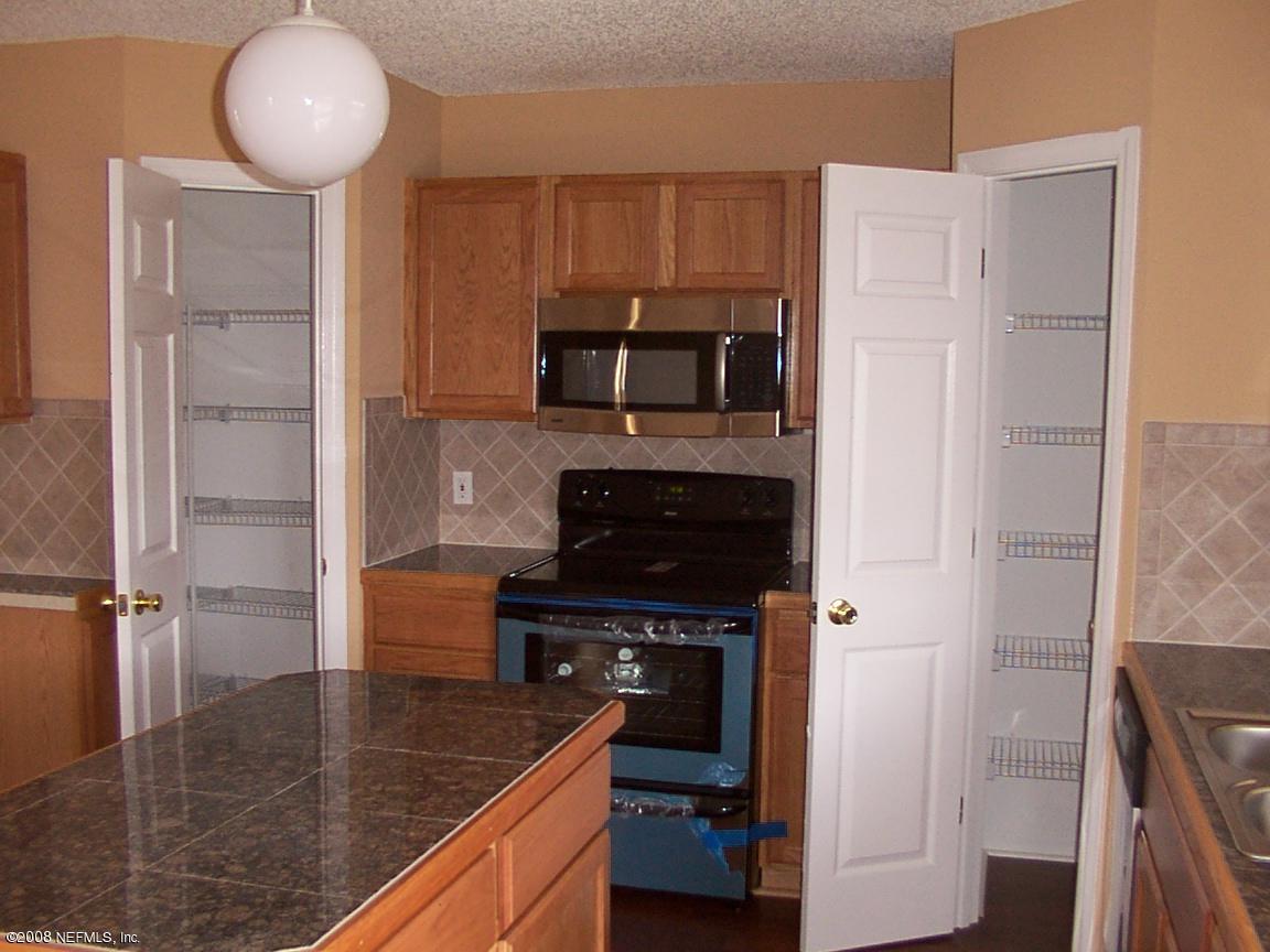 7316 Spring Hill Road Jacksonville, FL 32244 - Photo 5 of 11 a kitchen with kitchen island a counter space a sink and a stove