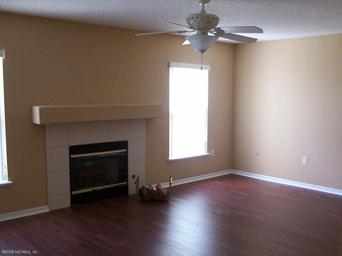 7316 Spring Hill Road Jacksonville, FL 32244 - Photo 7 of 11 a view of an empty room with wooden floor fireplace and a window