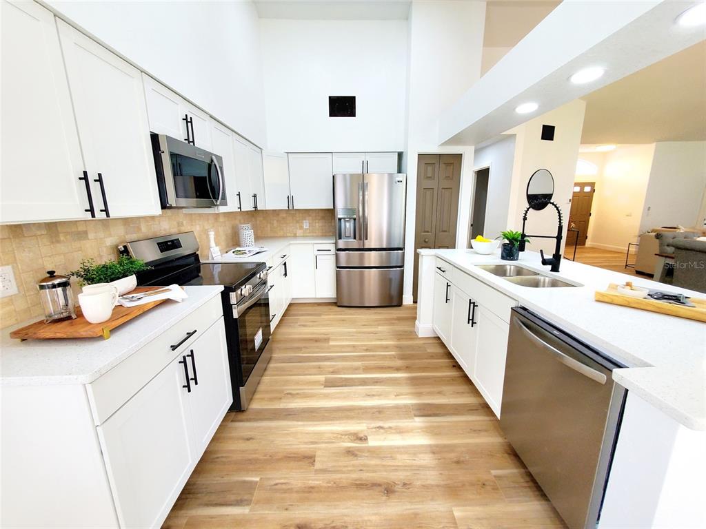 1517 Morning Rose Place Trinity, FL 34655 - Photo 12 of 50 a large kitchen with stainless steel appliances lots of counter space and wooden floor