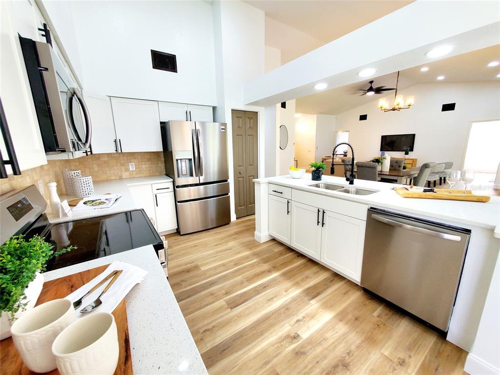 1517 Morning Rose Place Trinity, FL 34655 - Photo 13 of 50 a kitchen with stainless steel appliances a sink a stove a refrigerator and cabinets