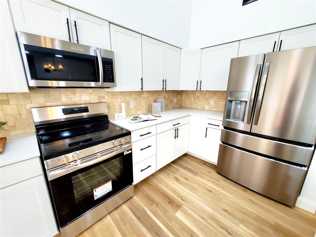 1517 Morning Rose Place Trinity, FL 34655 - Photo 14 of 50 a kitchen with stainless steel appliances a refrigerator stove and microwave