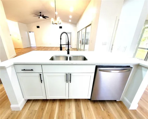 a close view of a sink a washer and dryer with wooden floor