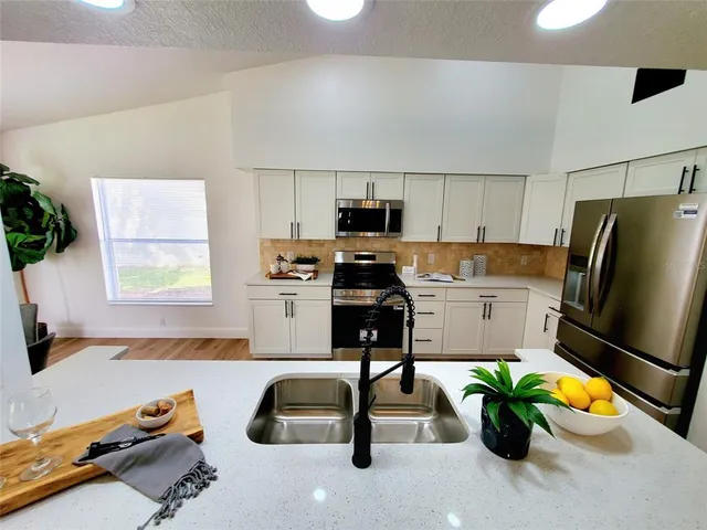 a kitchen with a refrigerator a stove and a sink
