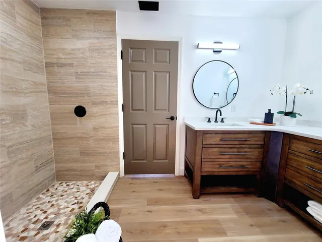 a bathroom with a sink a mirror and shower
