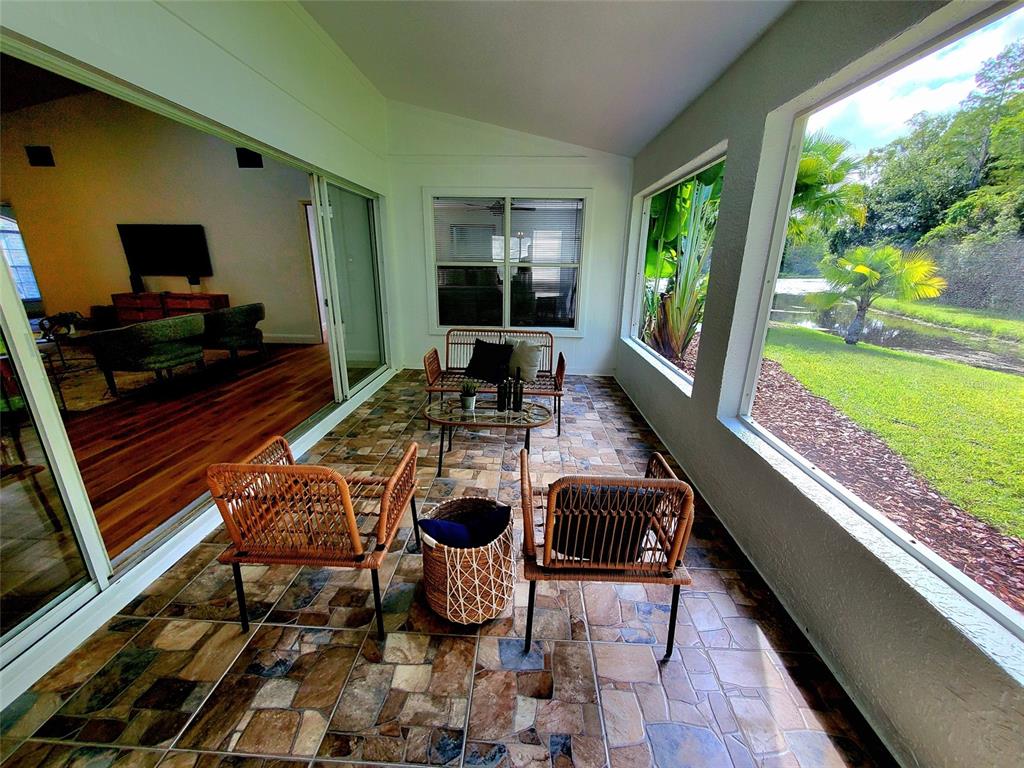 1517 Morning Rose Place Trinity, FL 34655 - Photo 44 of 50 a living room with patio furniture and a floor to ceiling window