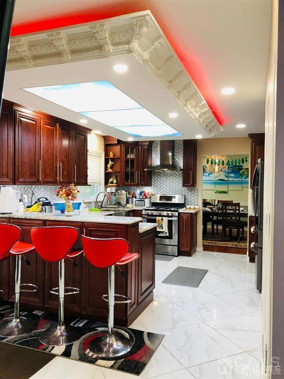 7 Calvert Avenue East Edison, NJ 08820 - Photo 14 of 47 a kitchen with stainless steel appliances kitchen island granite countertop a table and chairs