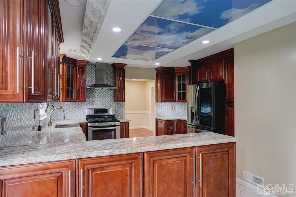 7 Calvert Avenue East Edison, NJ 08820 - Photo 19 of 47 a kitchen with stainless steel appliances granite countertop wooden cabinets a sink and a counter top space