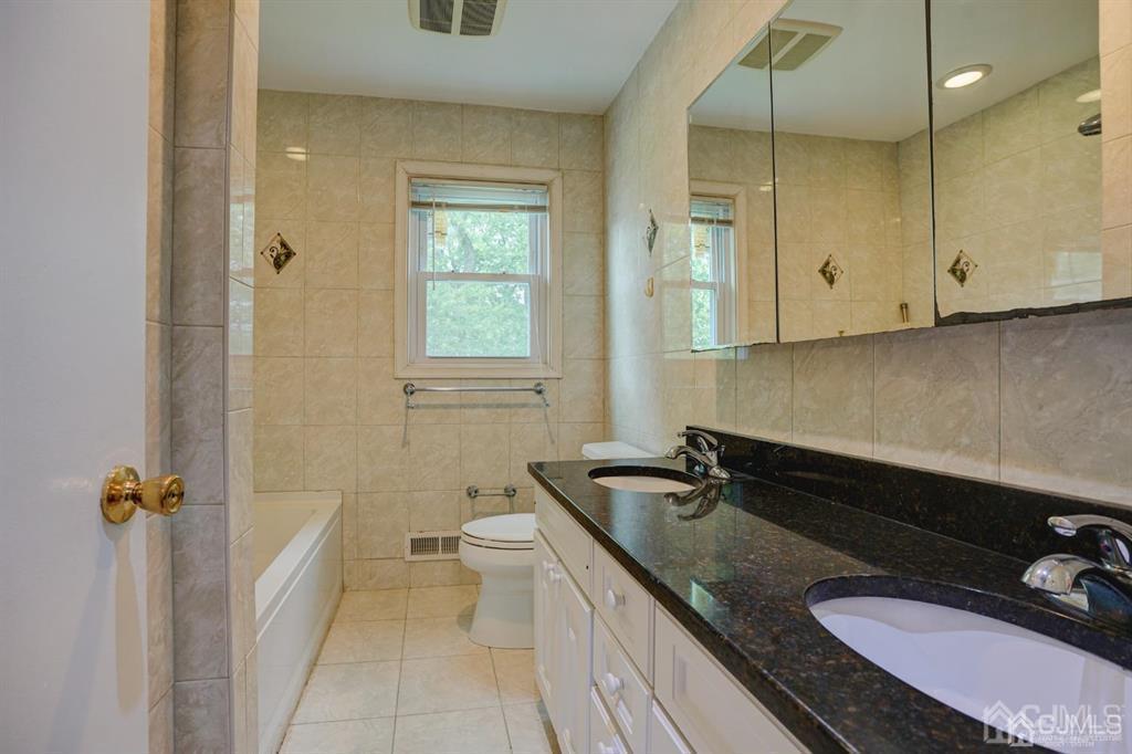 7 Calvert Avenue East Edison, NJ 08820 - Photo 40 of 47 a bathroom with a granite countertop sink a toilet a mirror and shower