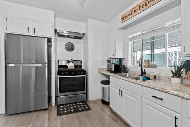 a kitchen with granite countertop a refrigerator and a sink