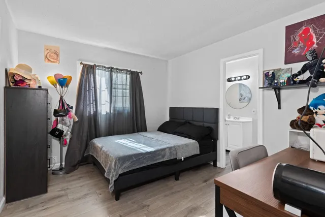 a bedroom with a bed and wooden floor