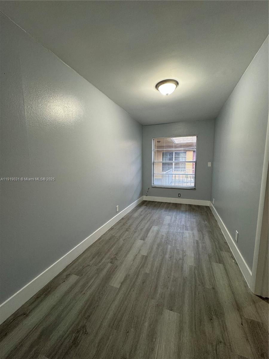 6840 Pembroke Road, Unit 202 Pembroke Pines, FL 33023 - Photo 5 of 7 an empty room with wooden floor and windows