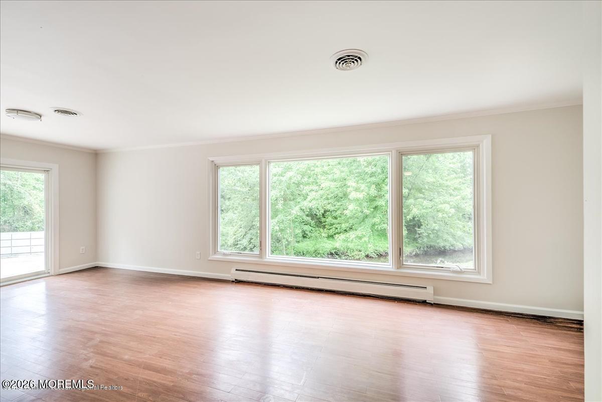 699 Aldrich Road Howell, NJ 07731 - Photo 9 of 23 an empty room with wooden floor and windows