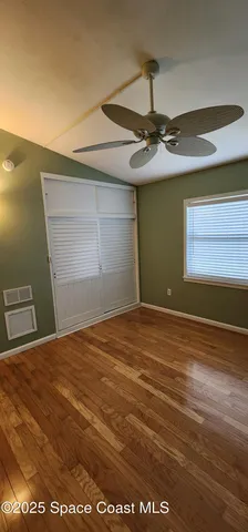 a view of empty room with window and ceiling fan