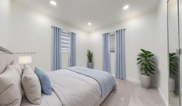 a bedroom with a bed and a potted plant