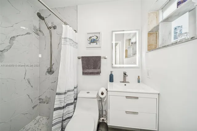 a bathroom with a sink toilet vanity and shower