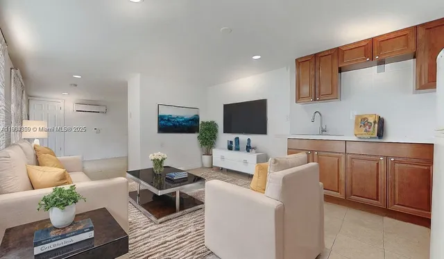 a living room with furniture a flat screen tv and kitchen view