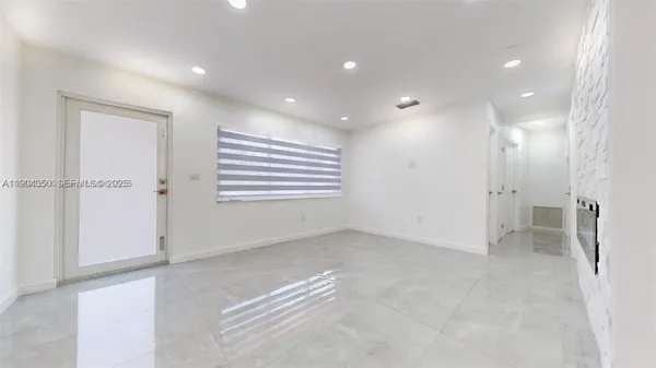 a view of an empty room with a fireplace and a window