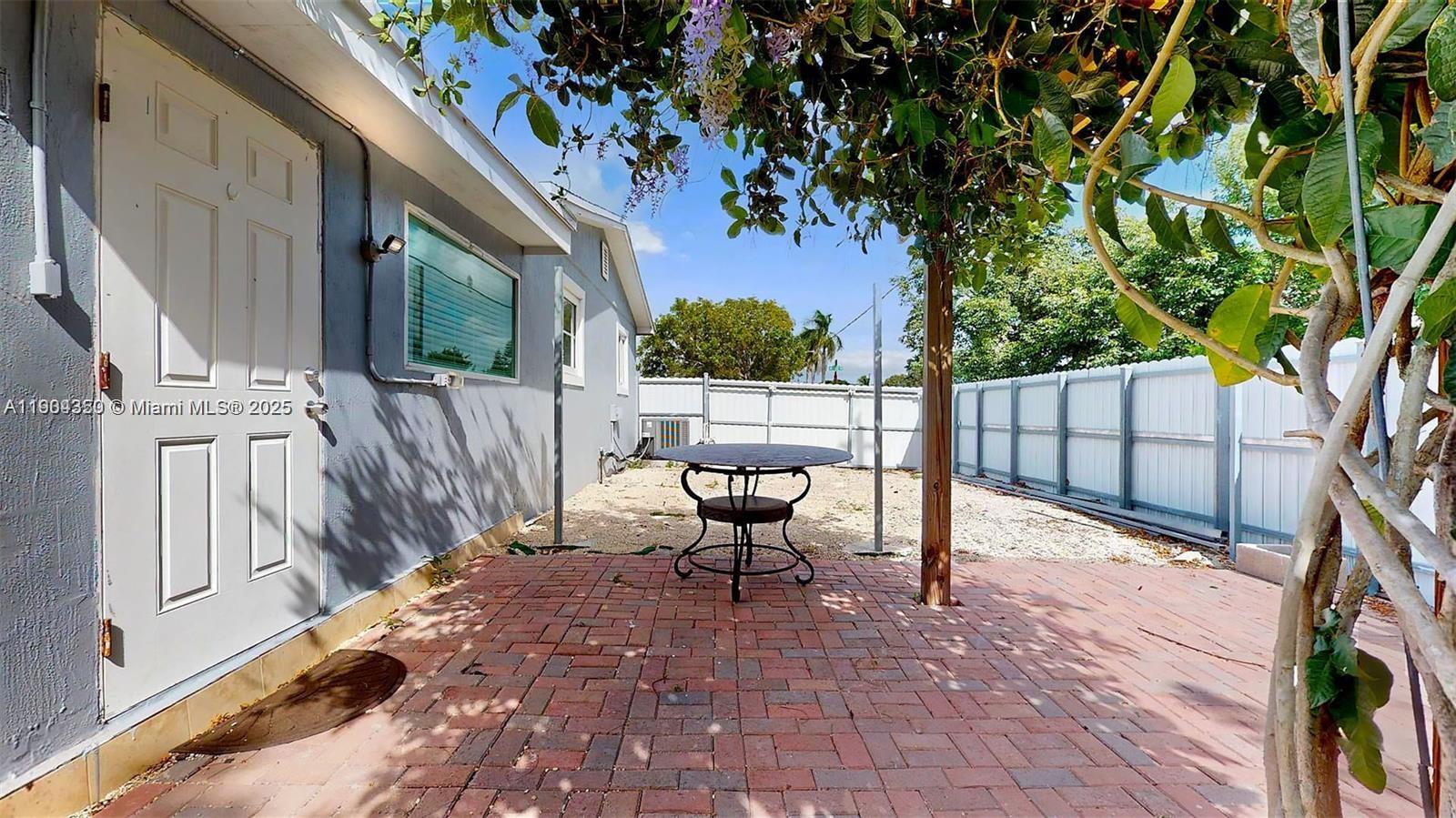 15704 Southwest 302nd Terrace Homestead, FL 33033 - Photo 21 of 26 a view of a patio with table and chairs with wooden floor and fence