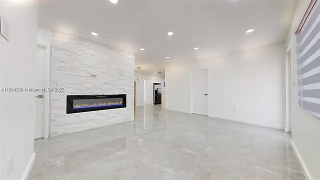 a view of an empty room with a fireplace and a window