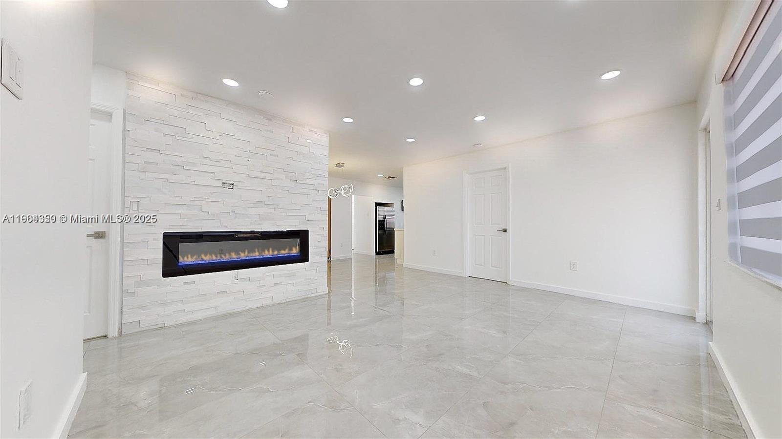 15704 Southwest 302nd Terrace Homestead, FL 33033 - Photo 3 of 26 a view of an empty room with a fireplace and a window