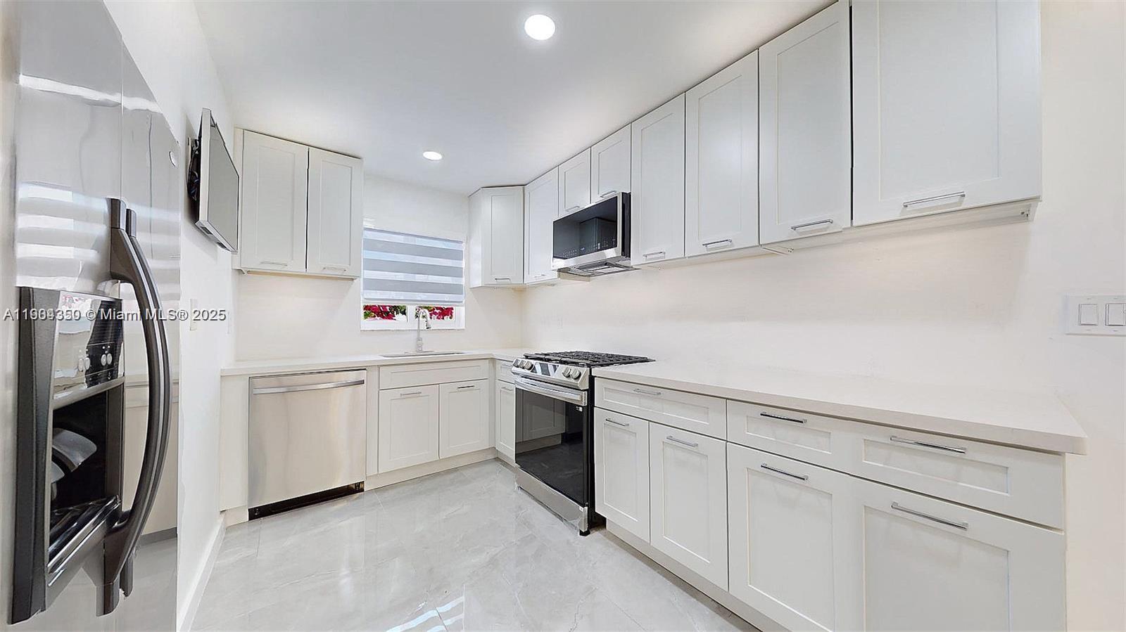 15704 Southwest 302nd Terrace Homestead, FL 33033 - Photo 7 of 26 a kitchen with white cabinets and stainless steel appliances