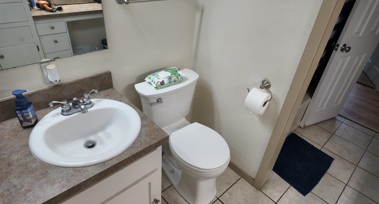 2709 Rice Avenue San Angelo, TX 76904 - Photo 13 of 28 a white toilet sitting next to a bathroom sink