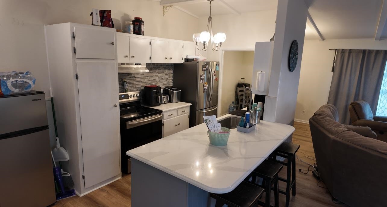 2709 Rice Avenue San Angelo, TX 76904 - Photo 8 of 28 a kitchen with stainless steel appliances granite countertop a refrigerator a sink a stove a dining table and chairs