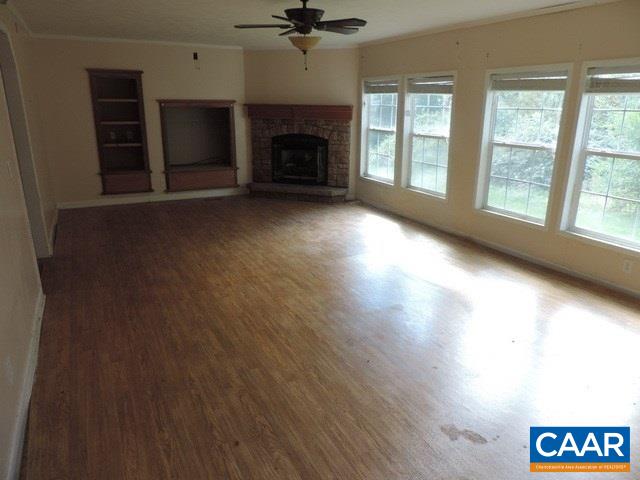377 Old Fort Road Buckingham, VA 23921 - Photo 7 of 16 an empty room with windows and a fireplace