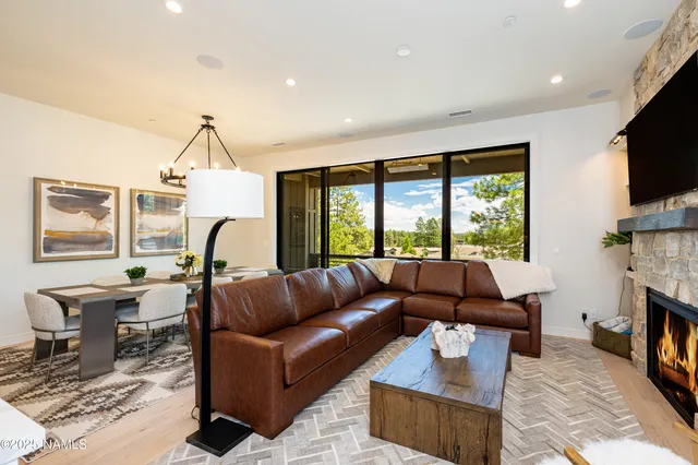 a living room with furniture fireplace and a large window