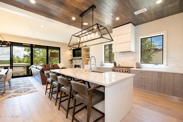 a dining hall with stainless steel appliances granite countertop a sink table and chairs