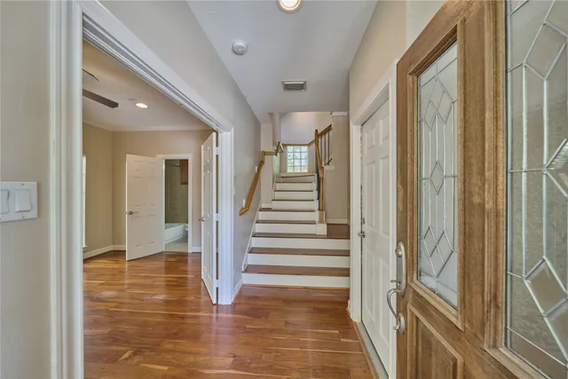 a view of a hallway with wooden floor and staircase