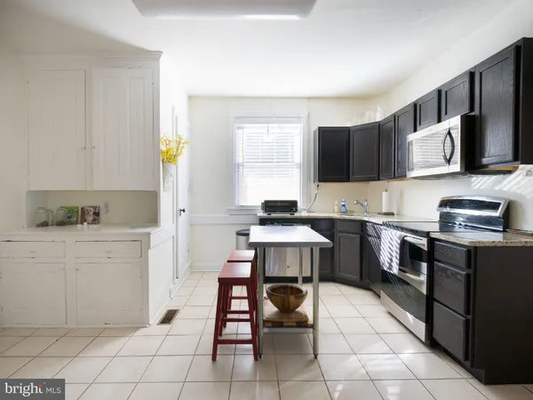 a kitchen with a stove a sink and a microwave