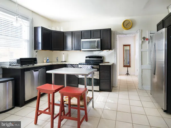 a kitchen with stainless steel appliances a stove a sink refrigerator and microwave