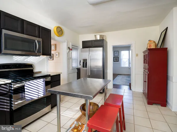 a kitchen with stainless steel appliances kitchen island granite countertop a refrigerator and microwave