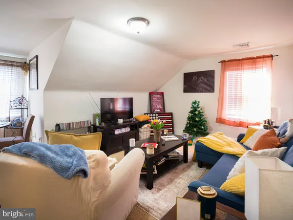 a living room with furniture a rug and a window