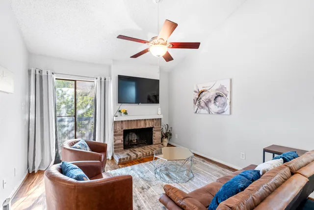 a living room with furniture a flat screen tv and a fireplace