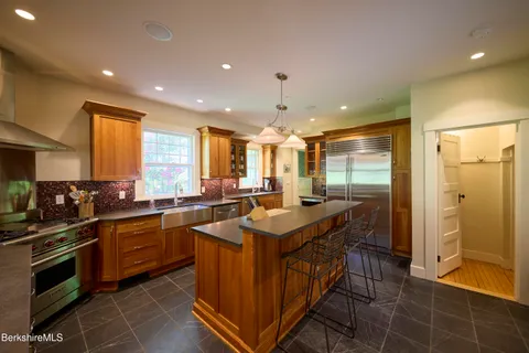a kitchen with stainless steel appliances granite countertop a sink and a refrigerator