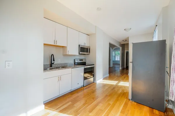 a view of empty room with wooden floor and ceiling fan