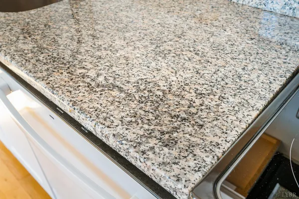 a close view of a sink a faucet and a stove in a kitchen