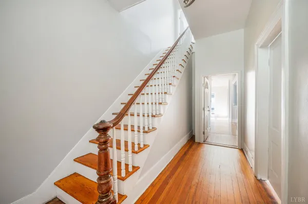 a view of a hallway with wooden floor and staircase
