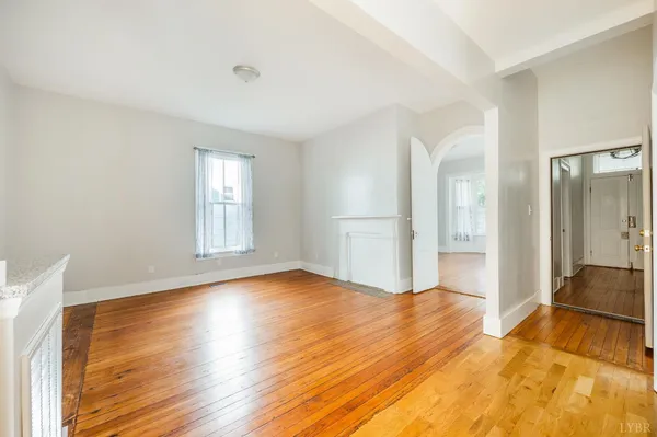a view of a livingroom with wooden floor and a kitchen