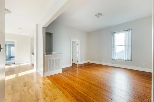 a view of empty room with wooden floor