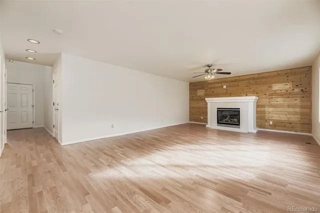 an empty room with wooden floor and fireplace