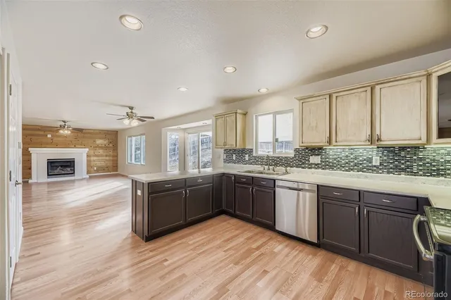 a large kitchen with wooden floors and stainless steel appliances